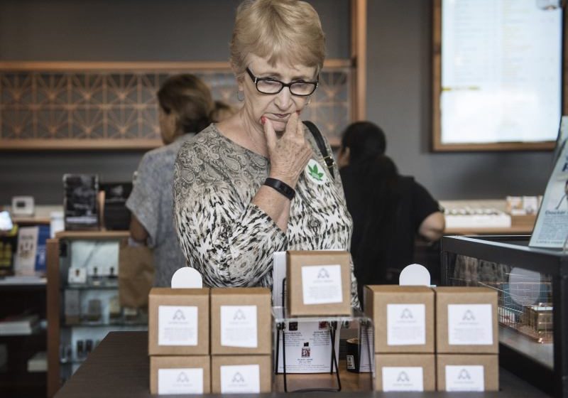Lynn Jarrett of Laguna Woods browses the different types of medicated cannabis products for sale at Bud and Bloom in Santa Ana, on Wednesday, August 2, 2017. Jarrett had never been to a dispensary before and was looking for a solution for pain in her mouth that traditional medication was not helping. (Photo by Nick Agro, Orange County Register/SCNG)